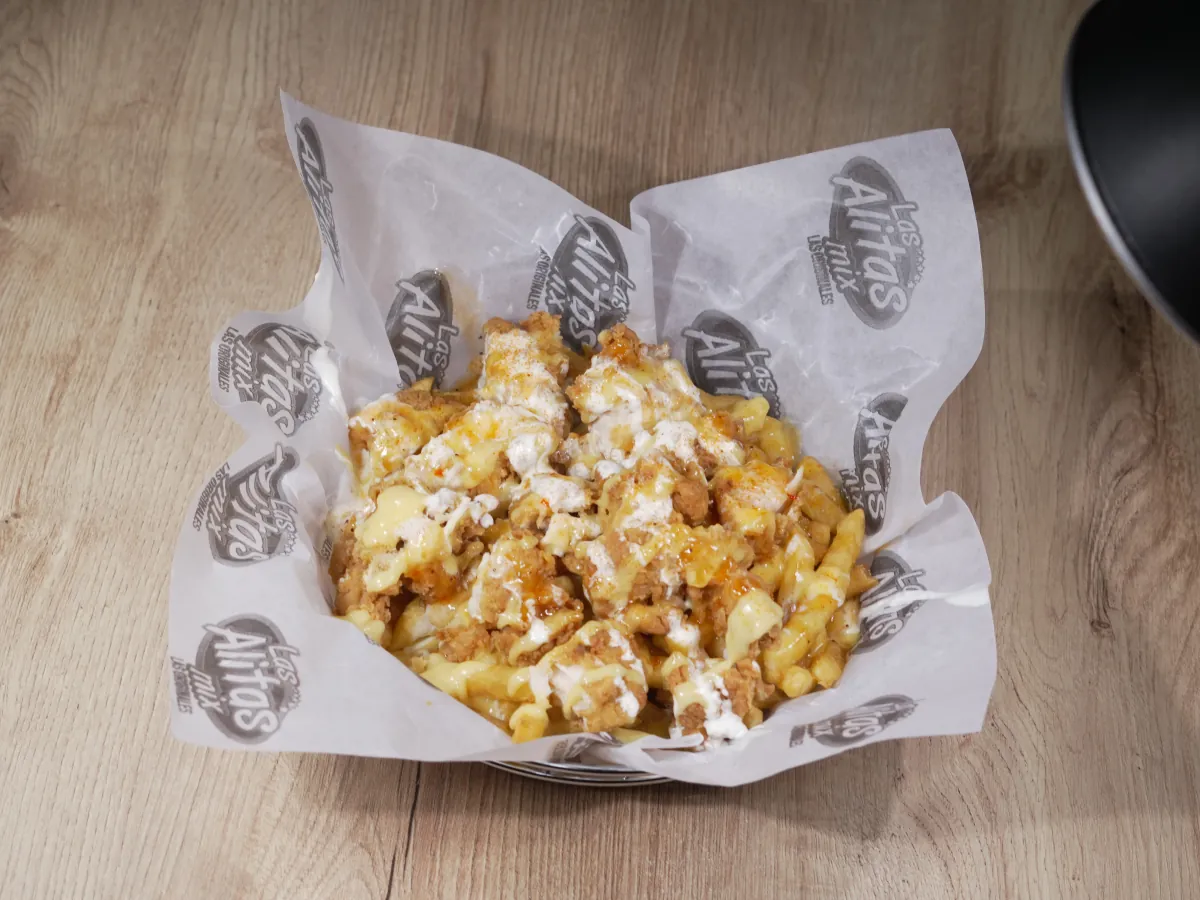 Papas Mix: papas a la francesa con trozos de pechuga apanada, salsas y queso crema en canasta